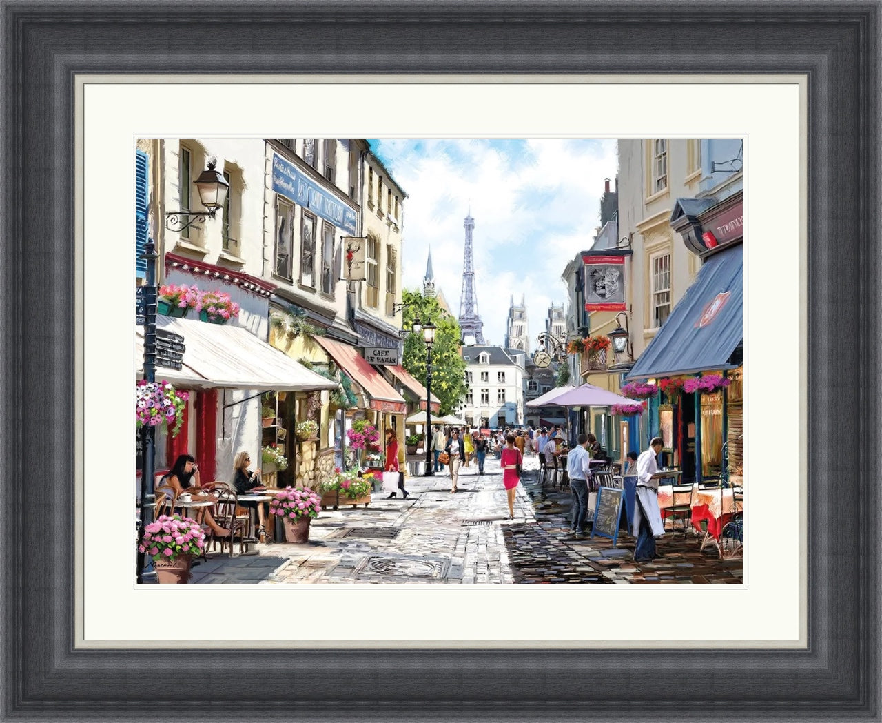 Framed artwork of a street scene with people and shops, featuring the Eiffel Tower.